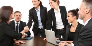 Ein Team mit den Vorgesetzen ist an einem Tisch versammelt. Foto: 089photoshootings, Unsplash.